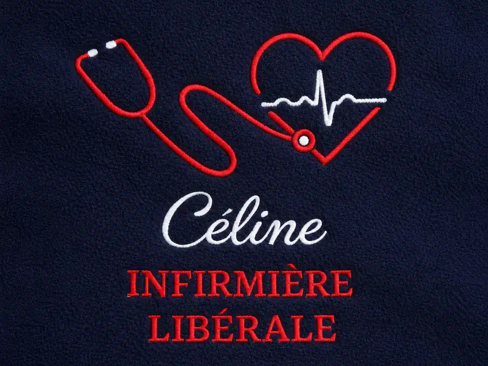 Zoom sur une broderie infirmière libérale rouge et blanche réalisée sur une polaire bleu marine personnalisée