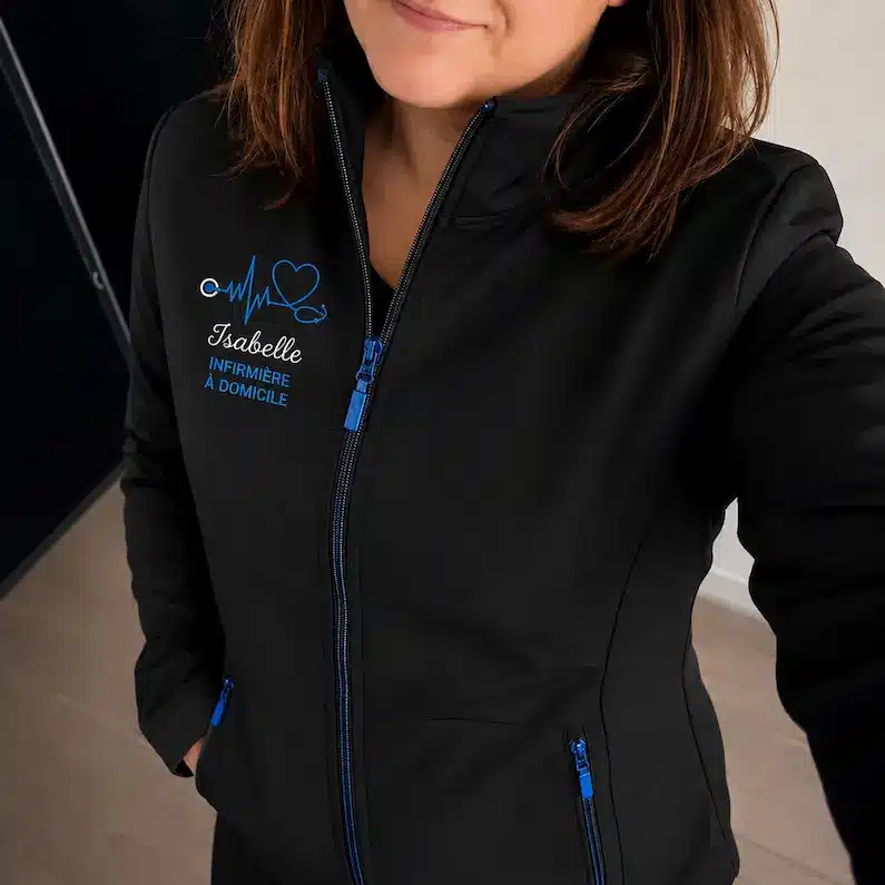 Infirmière portant une veste personnalisée noire avec broderie bleue Curalini
