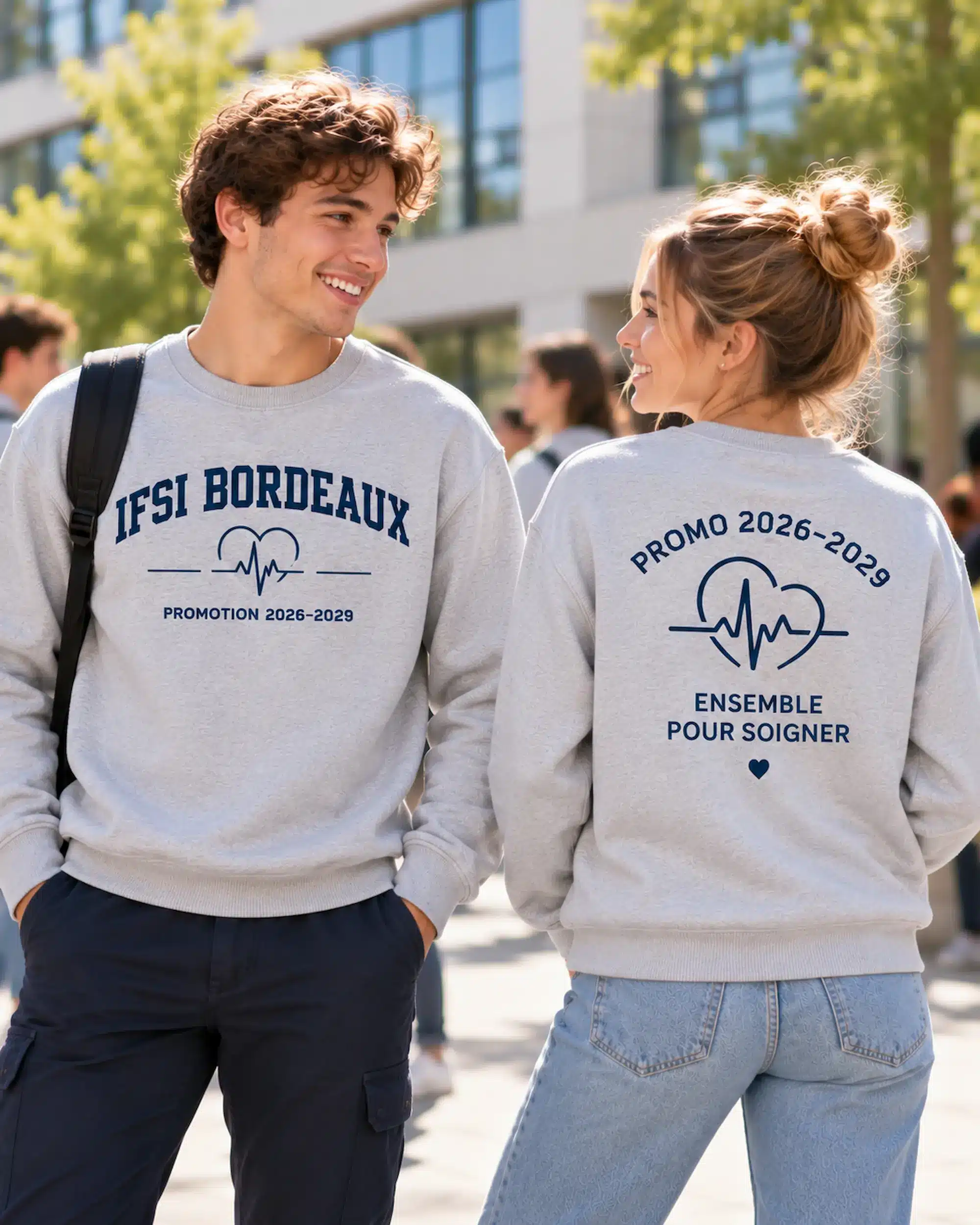 Deux étudiants portant des sweats col rond gris Oxford personnalisés pour l’IFSI Bordeaux, avec impressions bleu marine sur la poitrine et au dos.